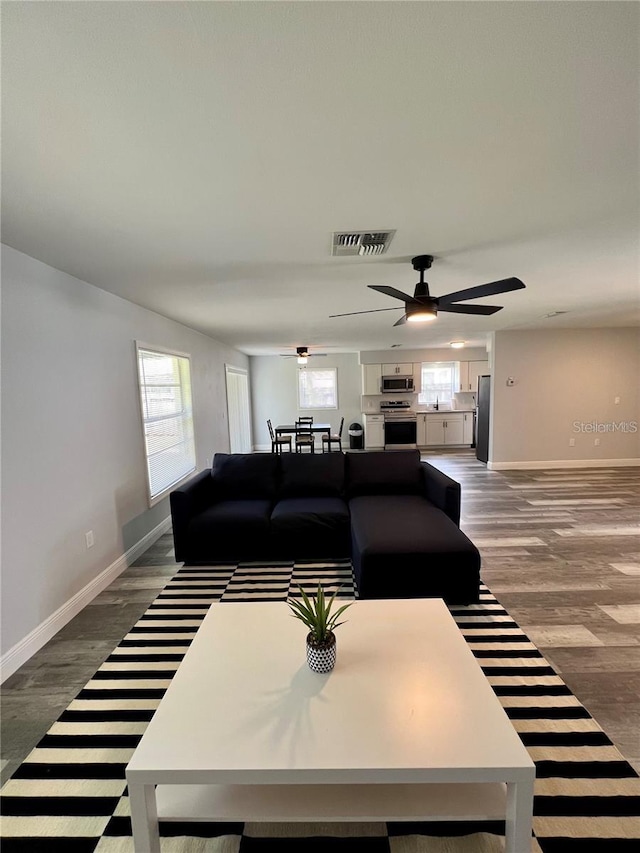 living room with wood-type flooring and ceiling fan