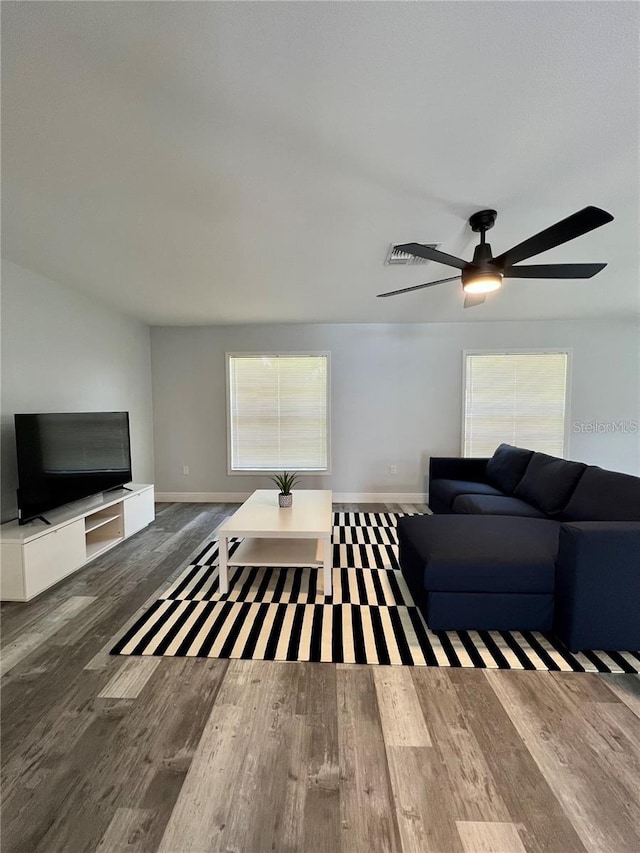 living room featuring ceiling fan and dark hardwood / wood-style flooring