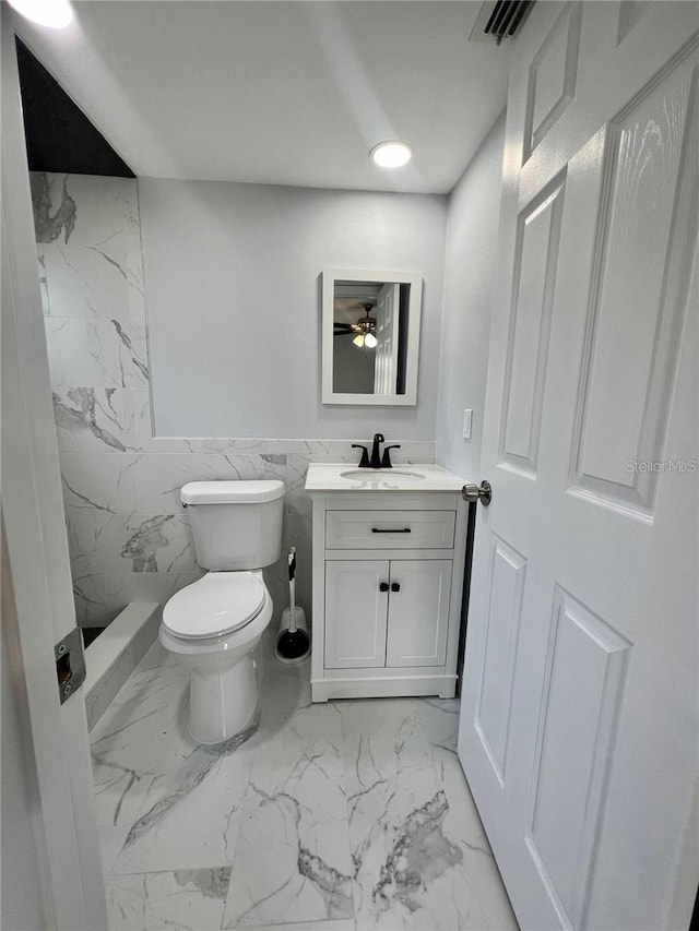 bathroom with vanity, walk in shower, and toilet