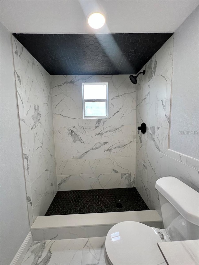 bathroom featuring a tile shower and toilet