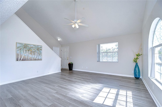 unfurnished living room with high vaulted ceiling, hardwood / wood-style floors, and ceiling fan