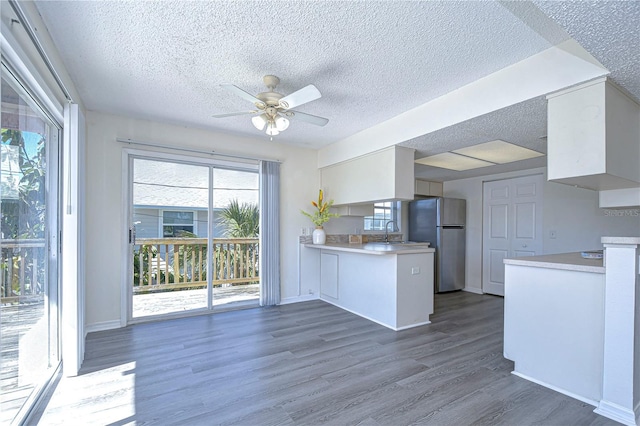 kitchen featuring sink, stainless steel fridge, ceiling fan, white cabinets, and dark hardwood / wood-style flooring