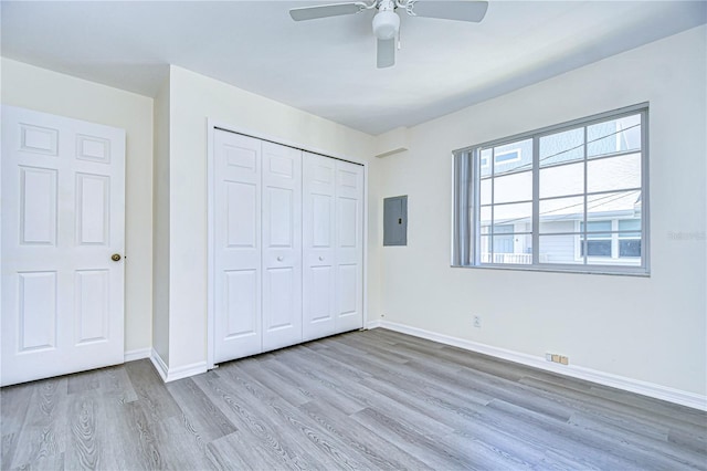 unfurnished bedroom with light hardwood / wood-style flooring, electric panel, a closet, and ceiling fan