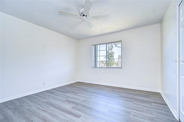 empty room featuring dark hardwood / wood-style floors, a textured ceiling, and ceiling fan