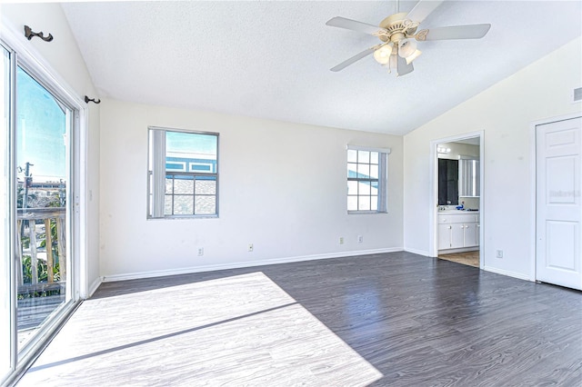 unfurnished room featuring ceiling fan, lofted ceiling, dark hardwood / wood-style floors, and a textured ceiling