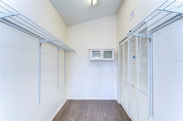 walk in closet with dark wood-type flooring