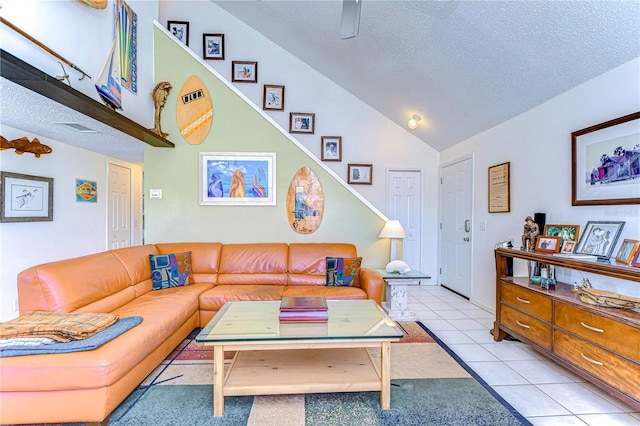 living room with light tile patterned flooring, ceiling fan, high vaulted ceiling, and a textured ceiling