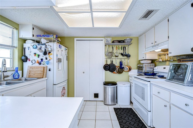 kitchen with light tile patterned flooring, sink, white cabinetry, a textured ceiling, and white appliances