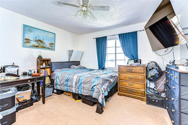 carpeted bedroom featuring ceiling fan and a textured ceiling