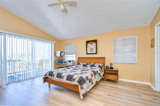 bedroom with ceiling fan, vaulted ceiling, light hardwood / wood-style floors, a textured ceiling, and access to outside