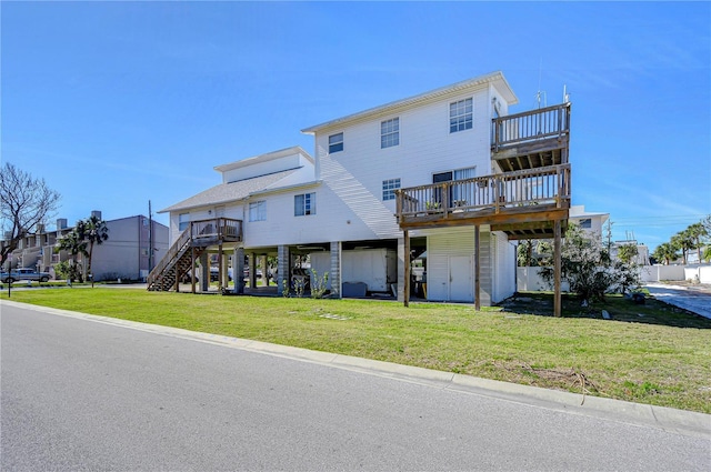 rear view of house featuring a wooden deck and a lawn