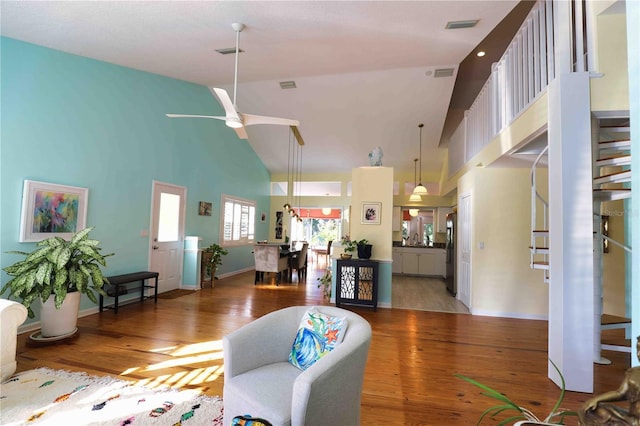 living room with hardwood / wood-style floors, high vaulted ceiling, and ceiling fan