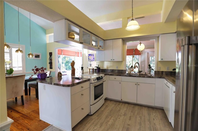 kitchen with sink, white appliances, kitchen peninsula, and white cabinets