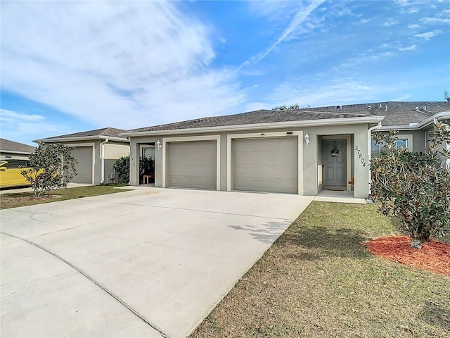 ranch-style house featuring a garage and a front lawn