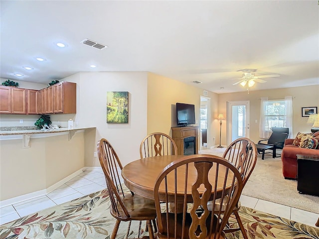 tiled dining space with ceiling fan