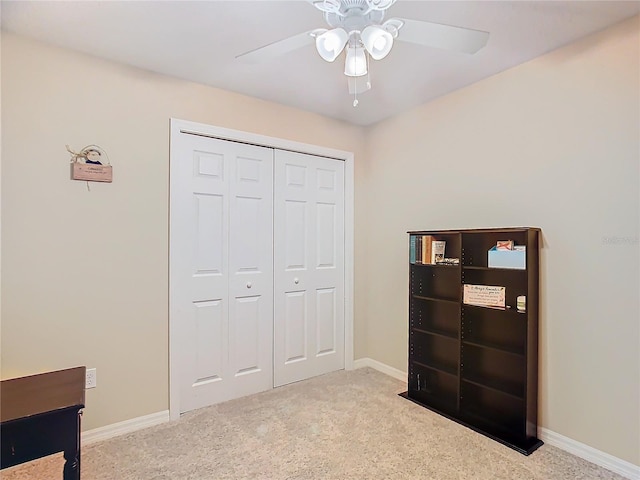 bedroom featuring light colored carpet, ceiling fan, and a closet