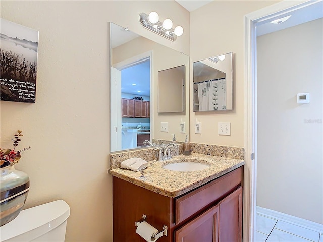 bathroom featuring tile patterned flooring, vanity, and toilet