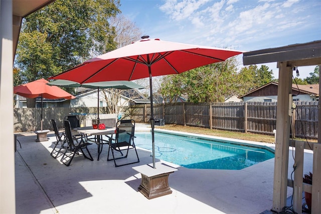 view of swimming pool featuring a patio, outdoor dining space, a fenced backyard, and a fenced in pool