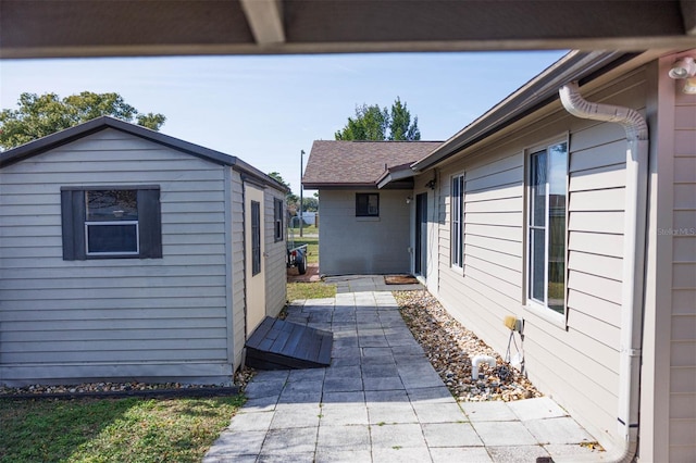 view of home's exterior with a patio area and roof with shingles