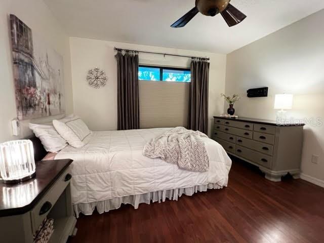 bedroom featuring wood finished floors, a ceiling fan, and baseboards