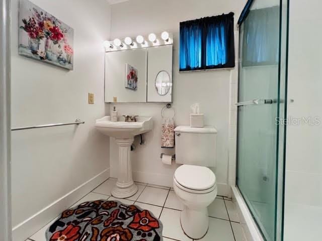 full bath featuring baseboards, an enclosed shower, toilet, and tile patterned floors