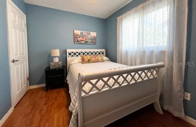 bedroom with baseboards and wood finished floors