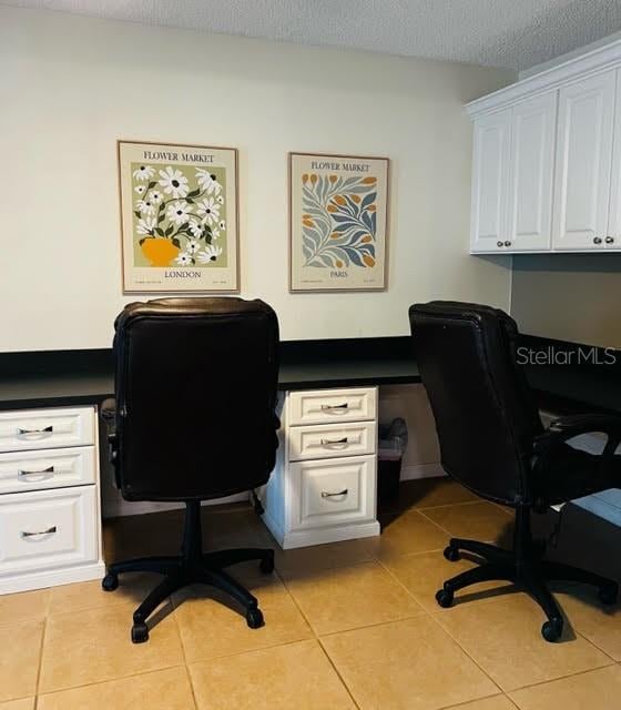 home office with light tile patterned floors and a textured ceiling