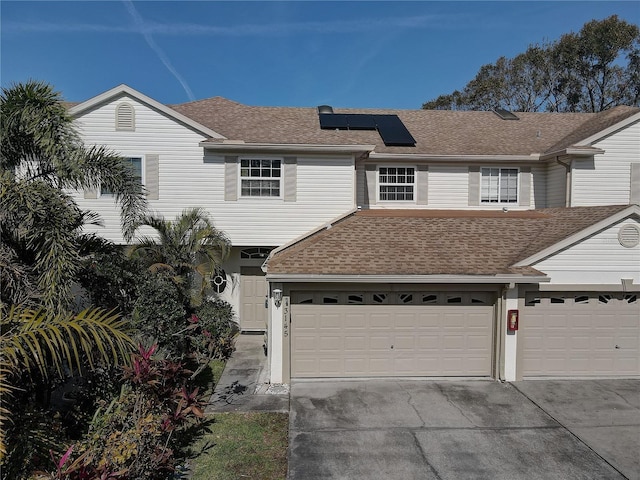 view of property with a garage and solar panels