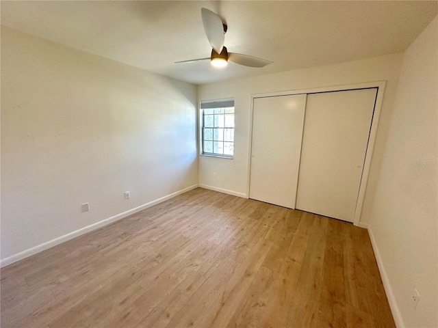 unfurnished bedroom featuring ceiling fan, light wood-type flooring, and a closet