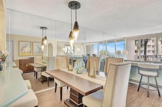 dining space with a textured ceiling and light hardwood / wood-style flooring