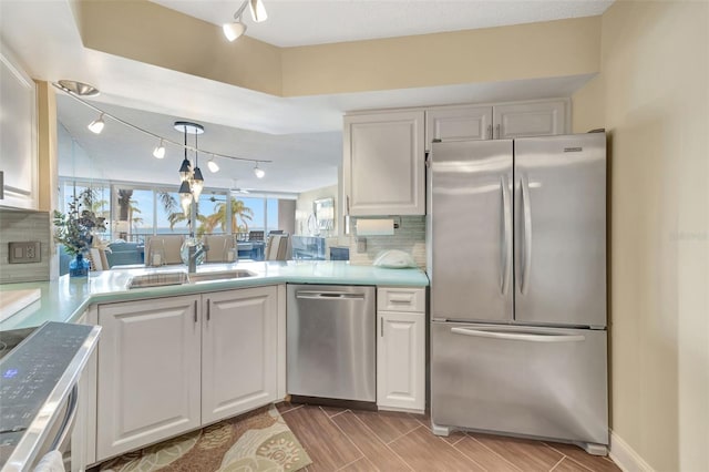 kitchen featuring white cabinetry, sink, decorative backsplash, and stainless steel appliances