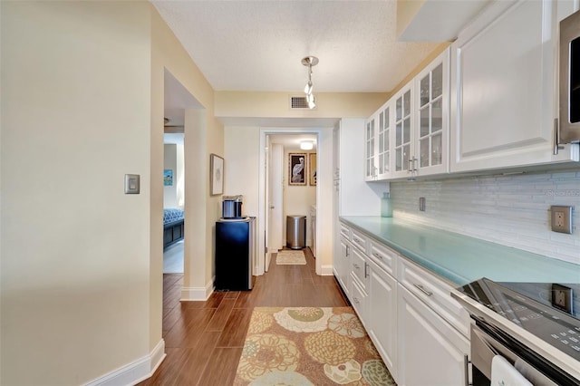 kitchen with white cabinetry, decorative light fixtures, decorative backsplash, and electric stove