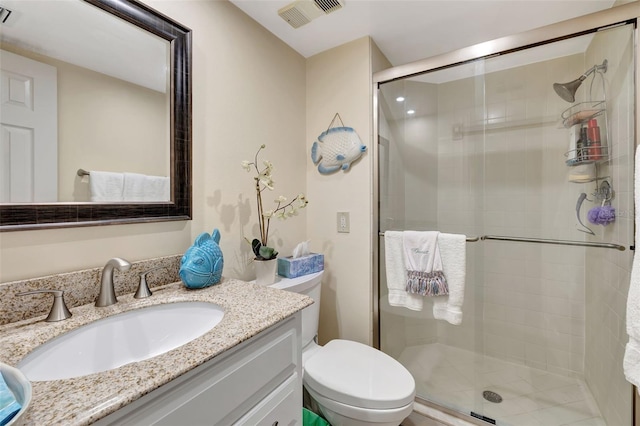 bathroom with vanity, toilet, and a shower with shower door