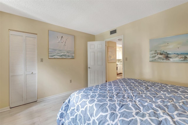 bedroom with light hardwood / wood-style flooring and a textured ceiling