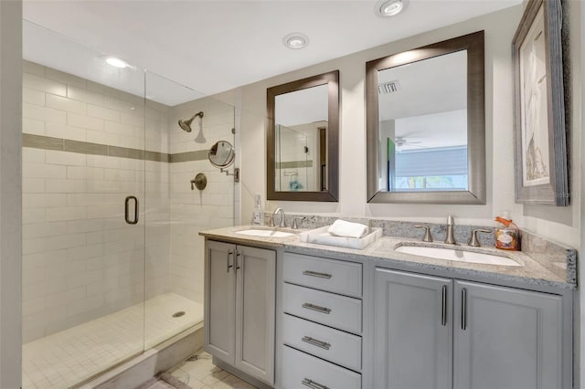 bathroom featuring a shower with door and vanity