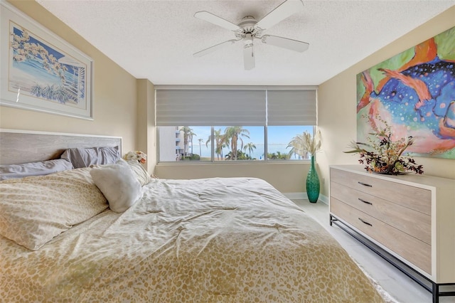 bedroom featuring ceiling fan and a textured ceiling