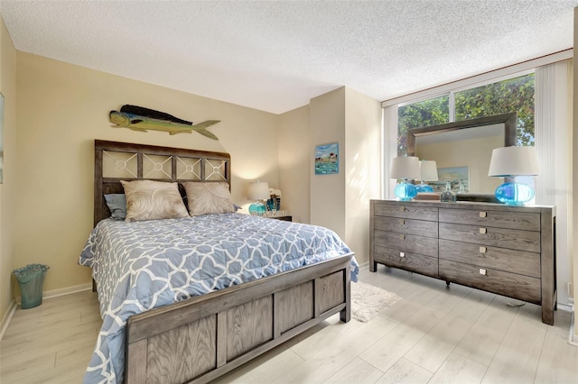 bedroom featuring light hardwood / wood-style floors and a textured ceiling