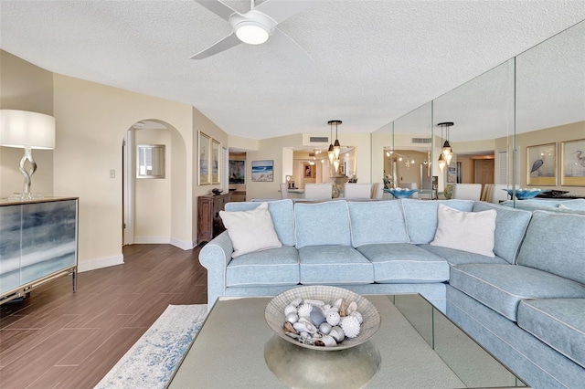 living room with hardwood / wood-style flooring, ceiling fan, and a textured ceiling