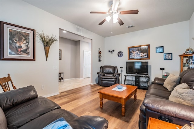 living area featuring light wood-style floors, ceiling fan, visible vents, and baseboards