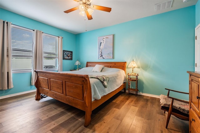 bedroom with baseboards, visible vents, and hardwood / wood-style floors