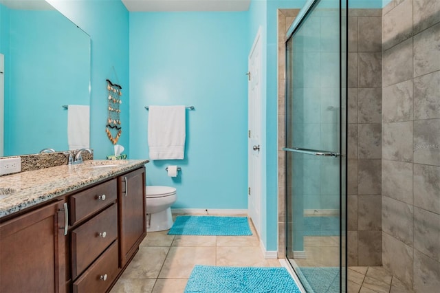 bathroom featuring toilet, a shower stall, vanity, tile patterned flooring, and baseboards