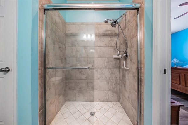 bathroom with ceiling fan, a shower stall, and connected bathroom