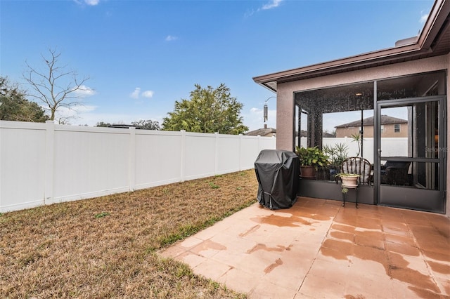 view of yard with a sunroom, a fenced backyard, and a patio