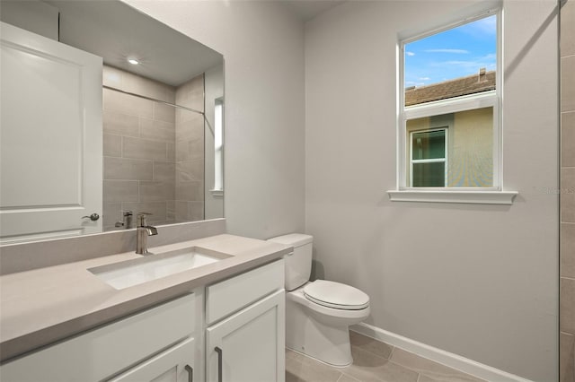 bathroom featuring tiled shower, vanity, toilet, and tile patterned flooring