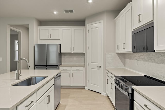 kitchen with white cabinetry, stainless steel appliances, sink, and tasteful backsplash