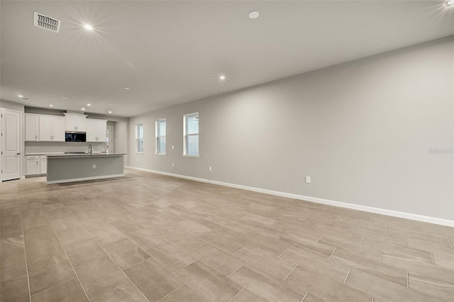 unfurnished living room featuring sink