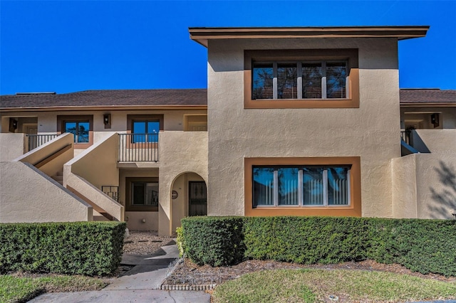 view of front of home featuring a balcony and stucco siding