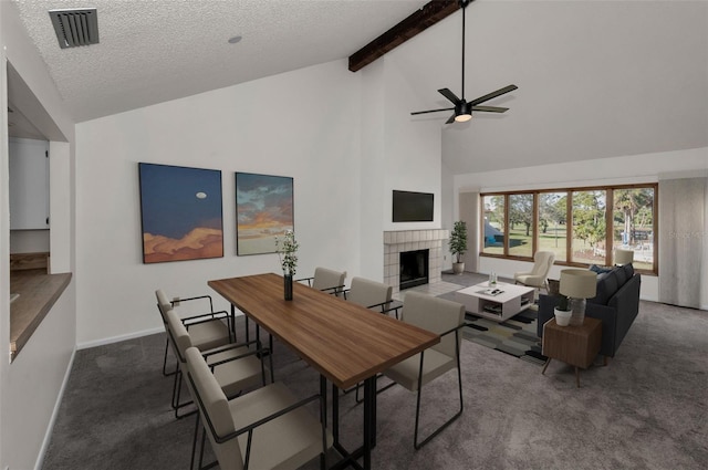 carpeted living room featuring a fireplace, visible vents, a textured ceiling, beamed ceiling, and baseboards