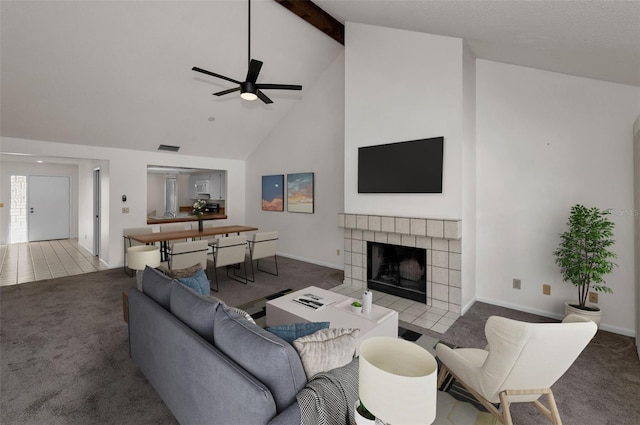 living room with beam ceiling, a ceiling fan, carpet flooring, high vaulted ceiling, and a tile fireplace