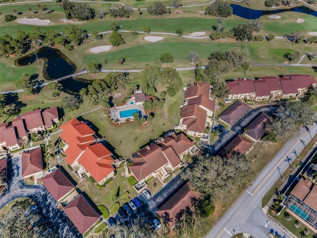 drone / aerial view with a residential view, view of golf course, and a water view